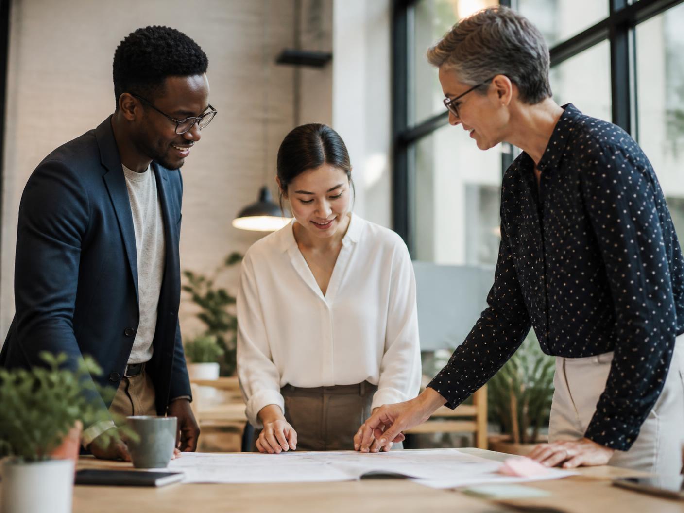 Three business professionals collaborating in a light-filled workspace